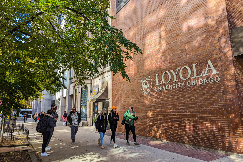 Students walk past the Arrupe College building on the Water Tower Campus